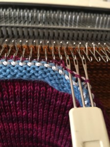 Close-up photo of transfer tool hanging stitches on knitting machine
