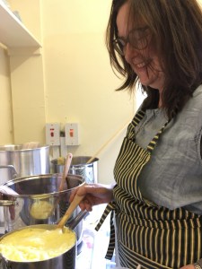 Woman stirs a dye vat after a chemical reaction