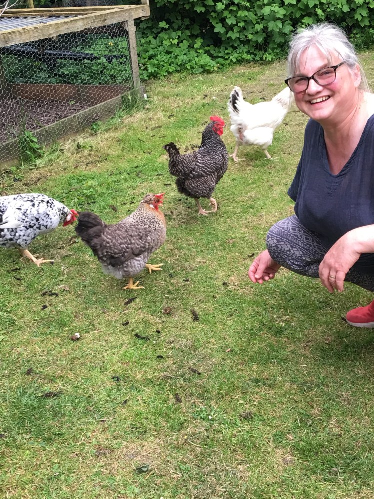 A woman in her garden in England with her chickens