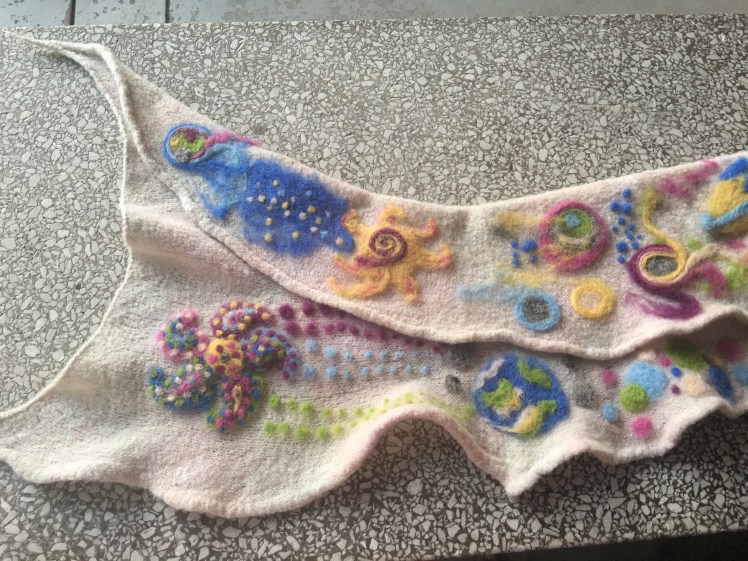 Paisleys arranged around a center with dotted vapor trails