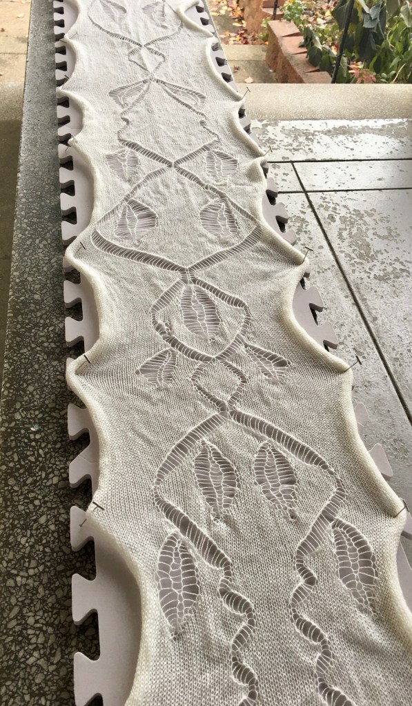 Hand-manipulated lace stitches in machine-knit fabric