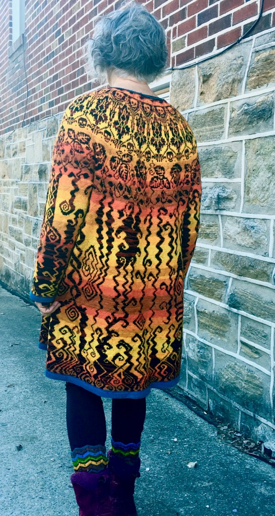 Rear view of knitted dress incorporating many symbols of societal ideas about the afterlife