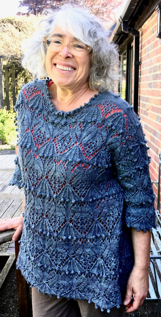 Modeled front view of pullover with relaxed fit and elaborate Japanese stitch pattern