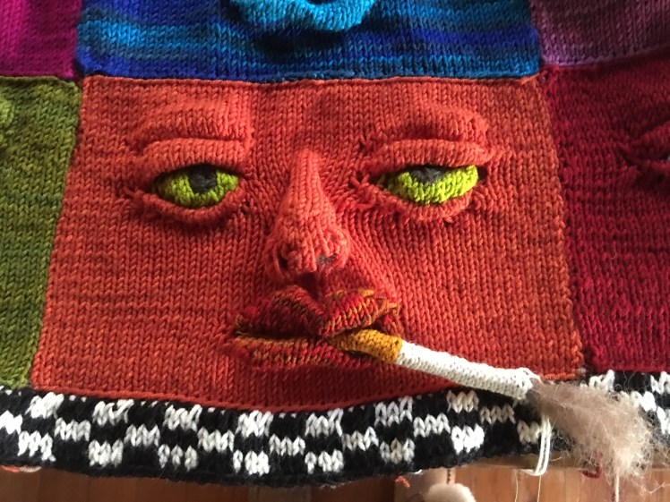 Knitted face with knitted cigarette