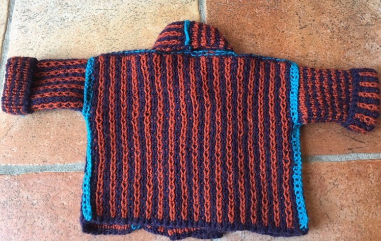 Knitted baby jacket with two-sided stitch pattern
