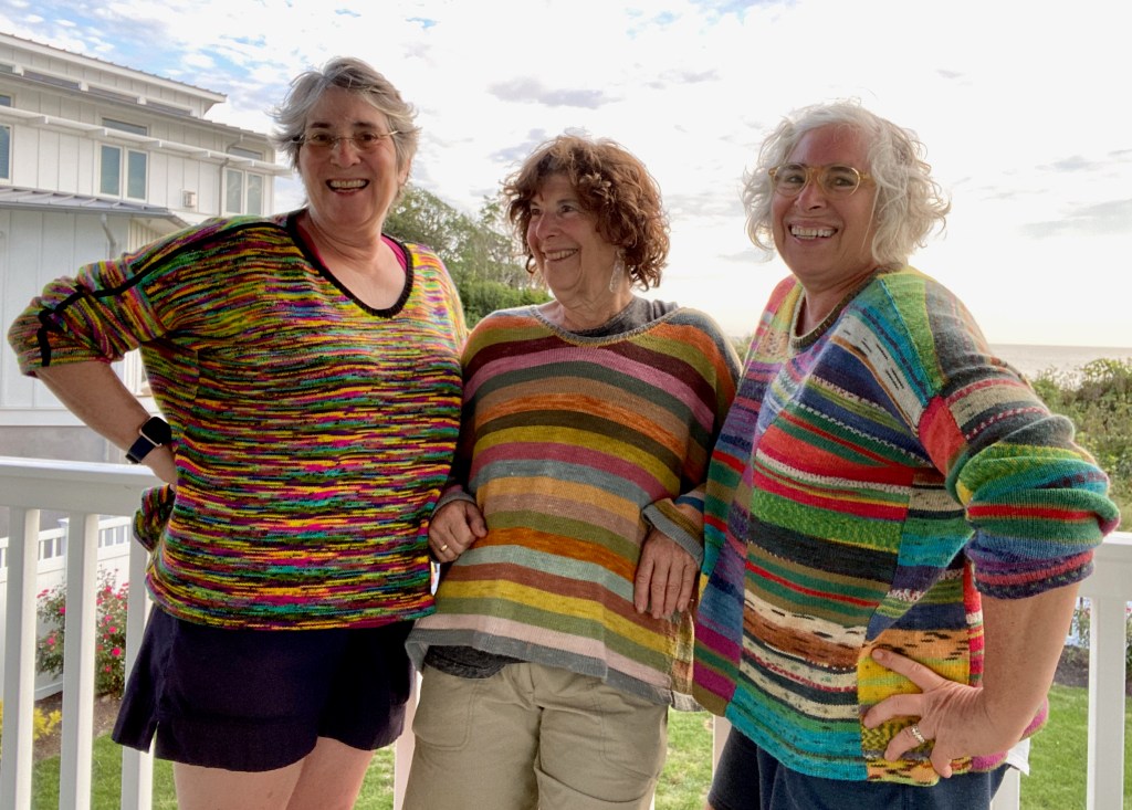 Three paneled machine-knit pullovers modeled