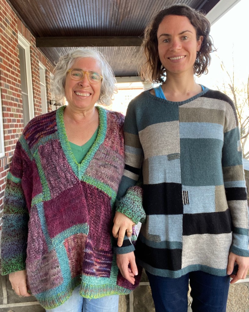 Mother-daughter sweaters of hand-knit patchwork pullover and machine-knit paneled pullover with intarsia and embroidery