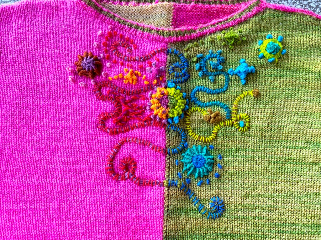 Completed embroidered embellishment on paneled machine-knit sweater, cool colors on green panel, warm colors on pink panel