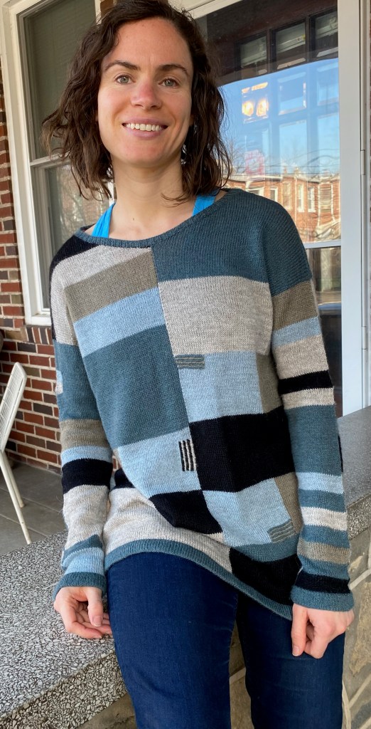 Modeled front view of machine knit, embroidered, intarsia sweater