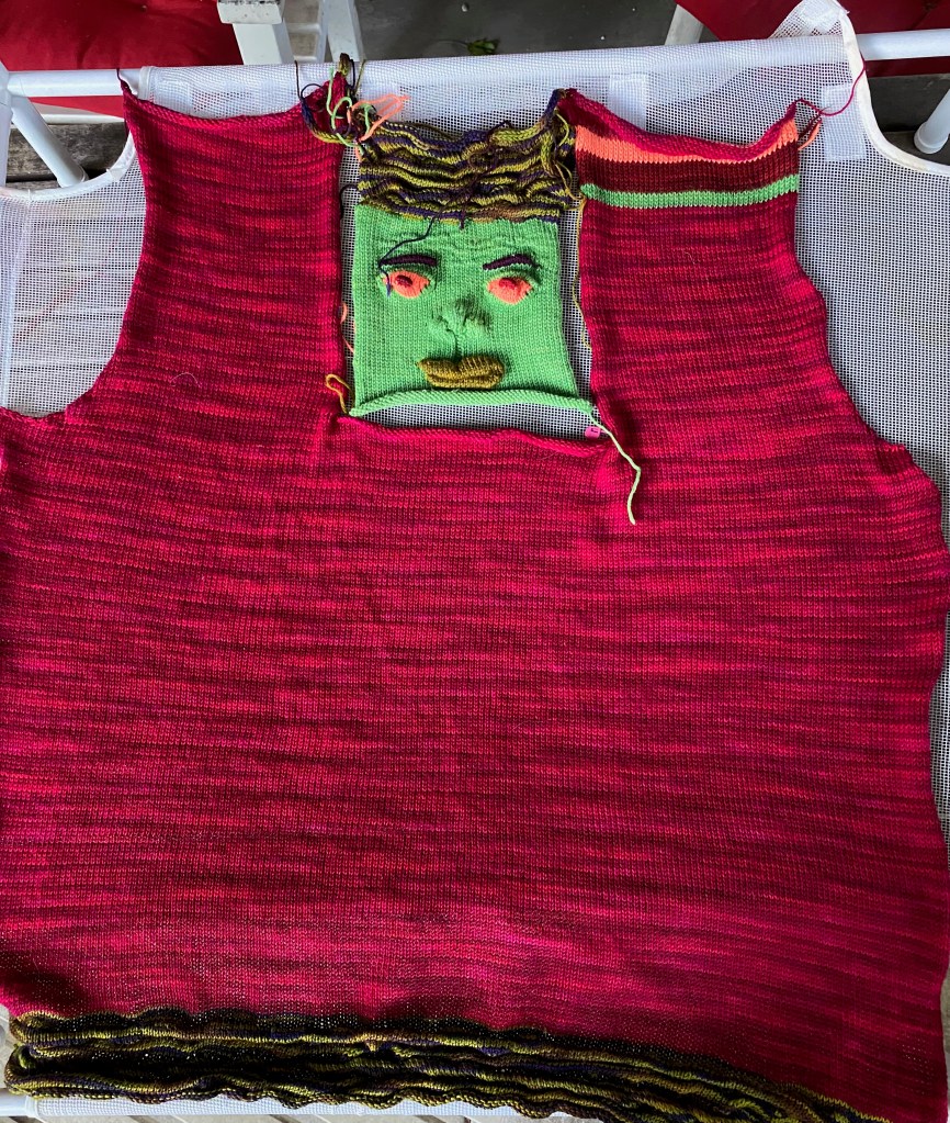 Sweater front with inset into which machine-knit face will be sewn