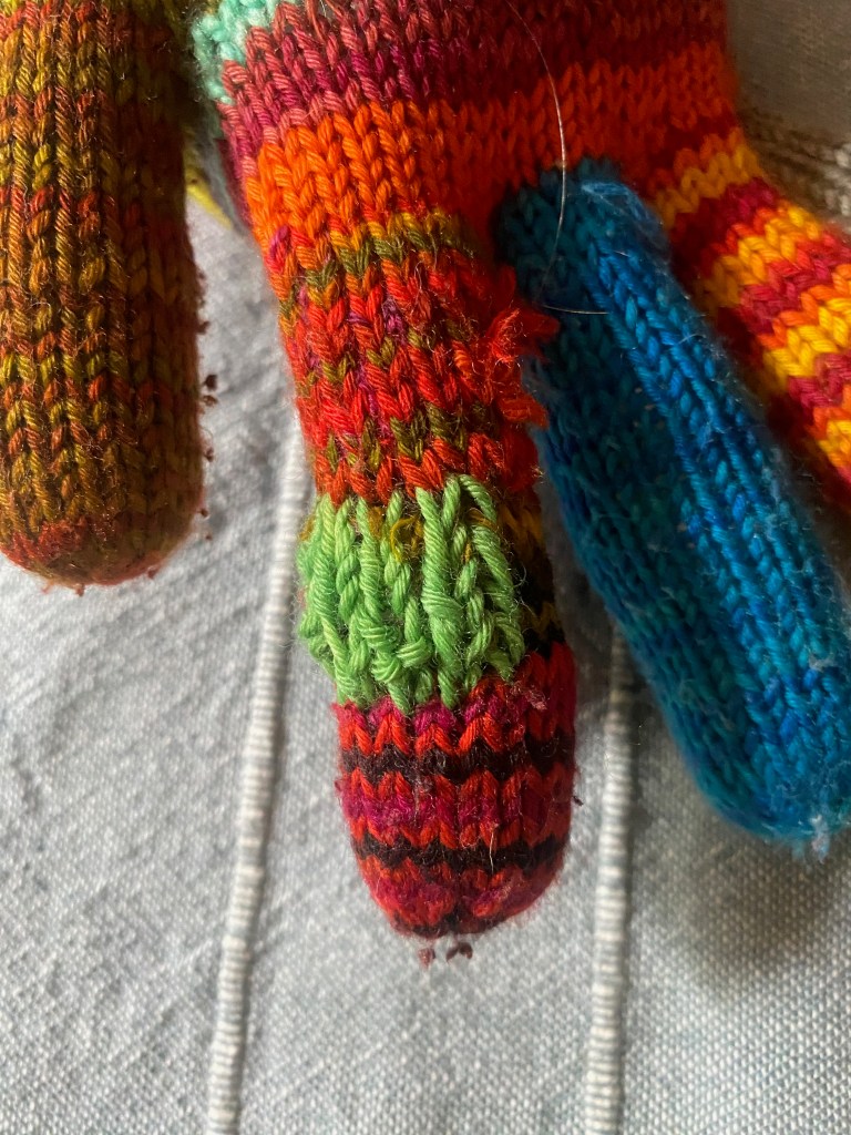 Detail of mending of large hole in knitted glove