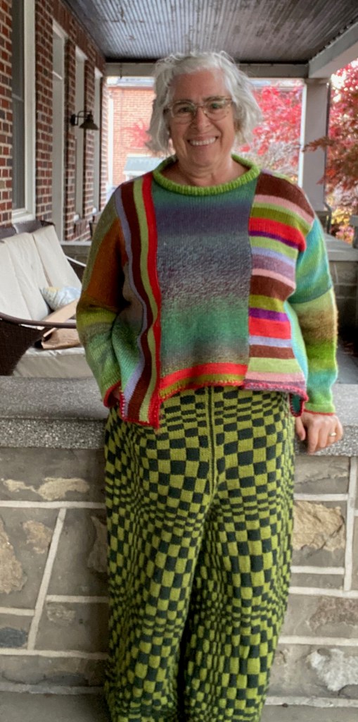 Op-art checkerboard pants paired with modular-construction sweater with stripes horizontally and vertically