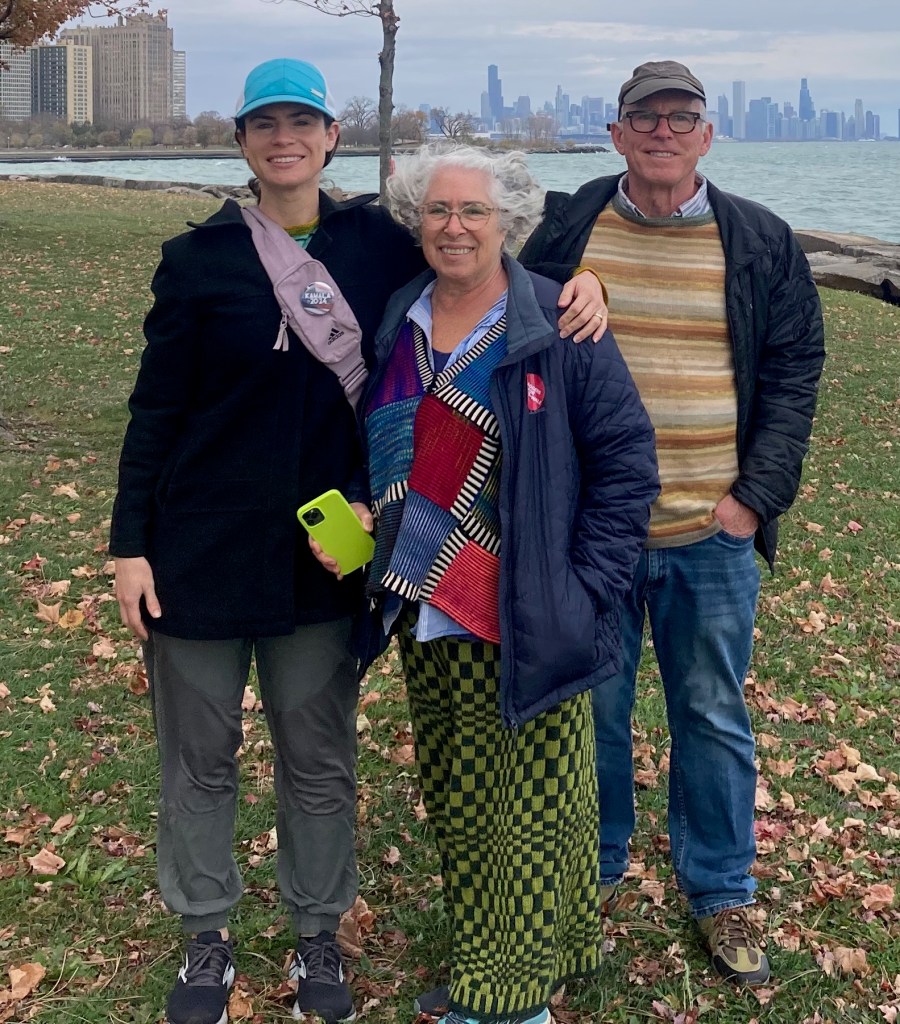 Op-art checkerboard pants worn with modular patchwork sweater
